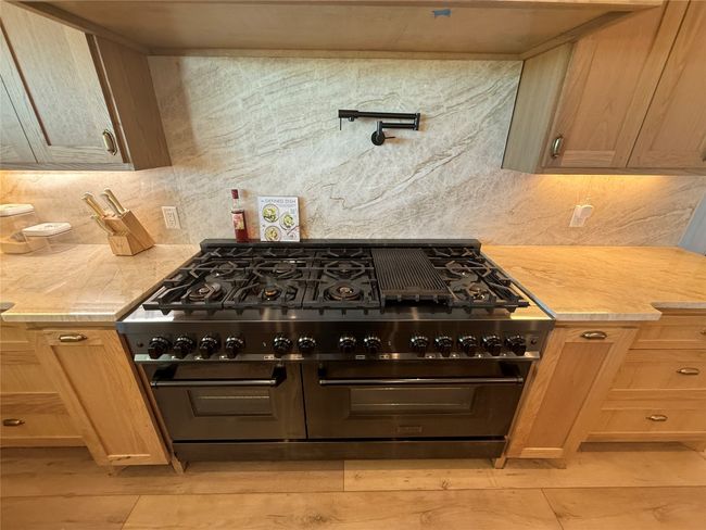 Kitchen featuring light countertops, double oven range, and tasteful backsplash | Image 26