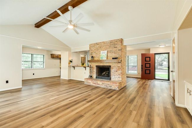 Vaulted ceiling with a large ceiling fan keep this space cool in the summer. Sit and relax in front of the cozy fire in the raised hearth brick fireplace in the winter. Breakfast area and kitchen to the left of the photo. Wet bar to the left of the fireplace. LVP throughout the living spaces of the home. | Image 10