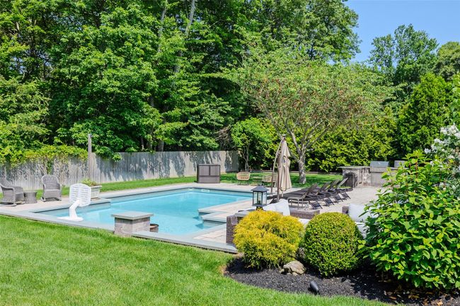 View of pool featuring a patio area and view of scattered trees | Image 40