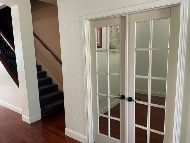 Detailed view of wood finished floors, french doors, and a textured wall | Image 4