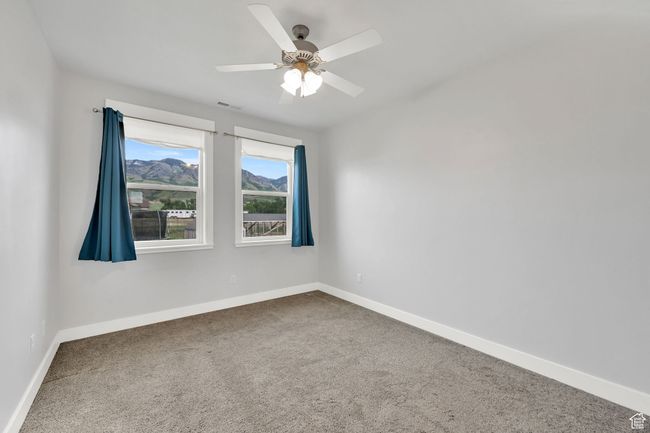 Carpeted spare room featuring baseboards and a ceiling fan | Image 54