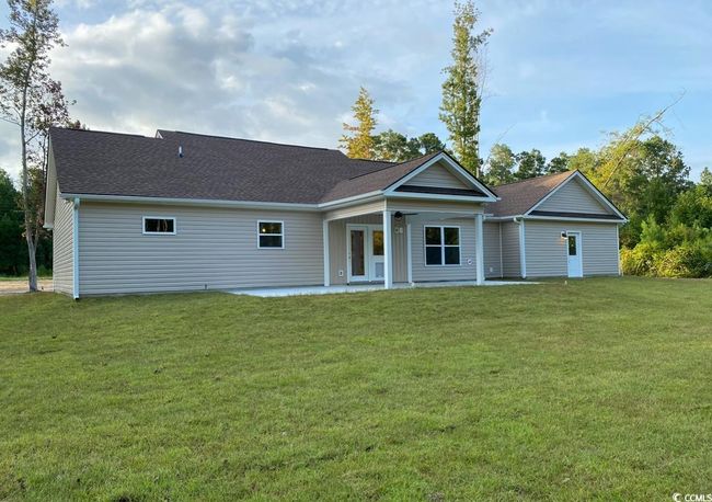 View of back of structure with a patio area, a rear yard, and roof with shingles | Image 14