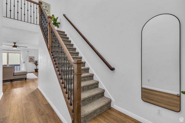 Stairway with baseboards, a ceiling fan, and wood finished floors | Image 10