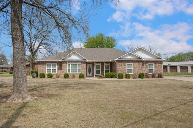 Ranch-style home with a front yard, brick siding, and roof with shingles | Image 49