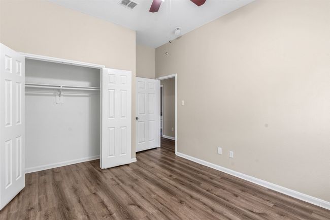 Unfurnished bedroom featuring baseboards, visible vents, a closet, and wood finished floors | Image 31