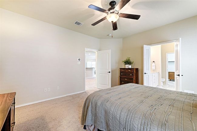 Bedroom with light carpet, ensuite bathroom, and a ceiling fan | Image 13