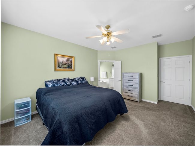 Carpeted bedroom with baseboards, visible vents, and ceiling fan | Image 17