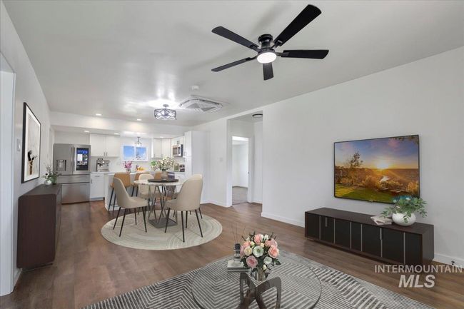 Dining room with dark wood finished floors and a ceiling fan | Image 5