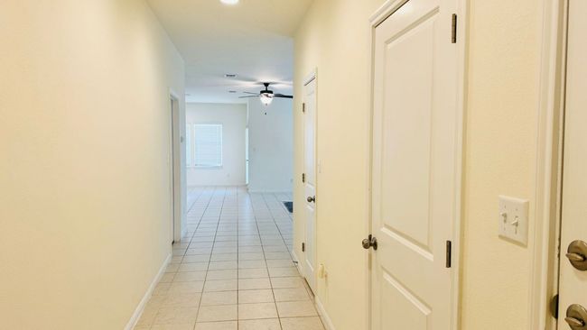 Hallway with light tile patterned flooring and baseboards | Image 8