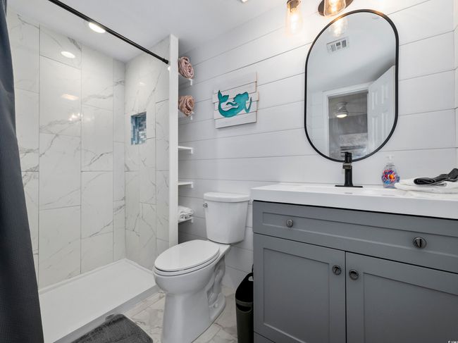 Full bathroom featuring visible vents, a shower stall, toilet, marble finish floor, and vanity | Image 17