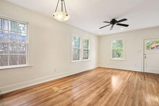 Empty room with light wood-type flooring and ceiling fan | Image 10