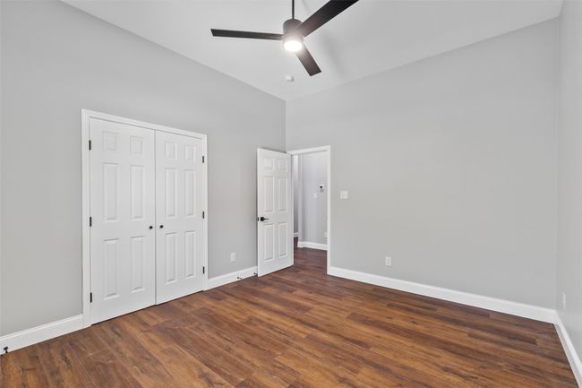 Unfurnished bedroom featuring a high ceiling, ceiling fan, and a closet | Image 17