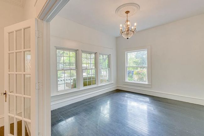 Spare room featuring a chandelier and dark wood-style floors | Image 6