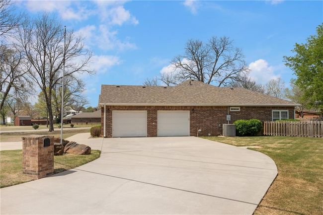 Single story home featuring a front yard, fence, brick siding, a garage, and driveway | Image 5