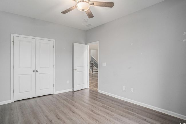 Unfurnished bedroom featuring wood finished floors, a closet, and a ceiling fan | Image 24