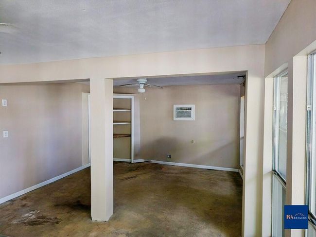 Bright and versatile room adjacent to the garage, perfect for a game room or extra storage, with abundant natural light from multiple windows. | Image 26