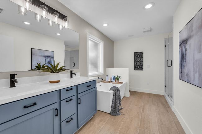 Bathroom featuring a stall shower, a soaking tub, a sink, and visible vents | Image 39
