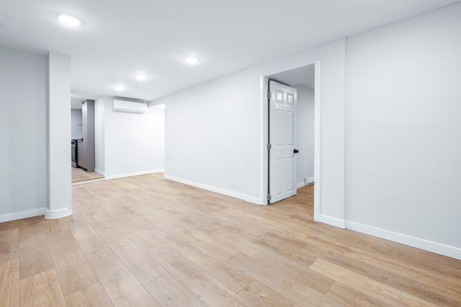 Finished basement with an AC wall unit, light wood-style flooring, recessed lighting, and baseboards | Image 6