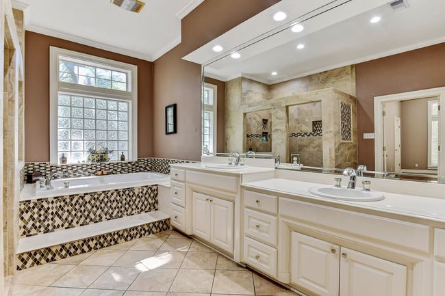 Full bathroom featuring a bath, a sink, ornamental molding, and a tile shower | Image 17