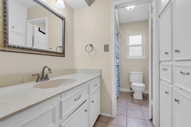 Spacious guest bathroom with tile flooring and plenty of built-ins. | Image 29