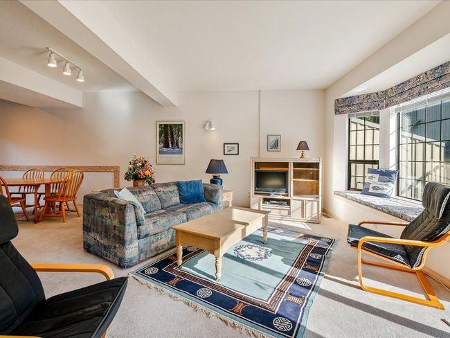 Living area with carpet floors, baseboards, beamed ceiling, and track lighting | Image 4