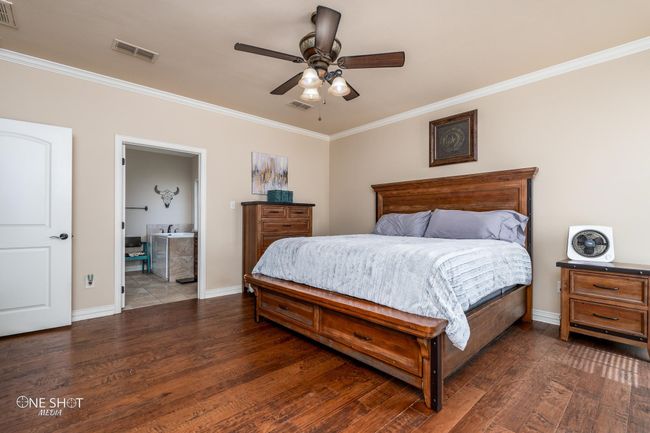 Bedroom featuring ornamental molding, wood finished floors, baseboards, and a ceiling fan | Image 20