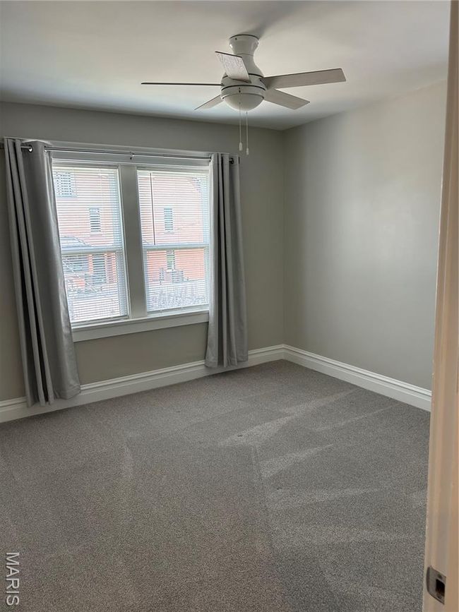 Carpeted spare room with healthy amount of natural light and ceiling fan | Image 14