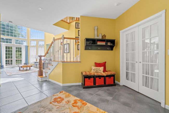 Foyer with double French doors leading to dining room, now utilized as office. Porcelain flooring imported from France. | Image 8