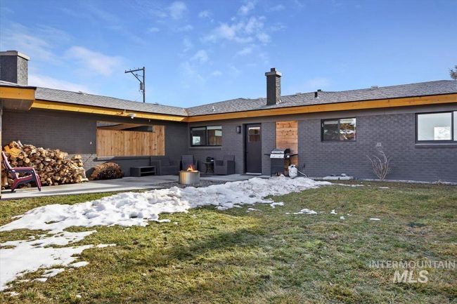 Back of property featuring a chimney, a yard, a patio, and brick siding | Image 23