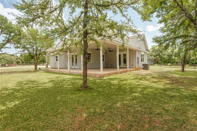 Back of house with french doors, ceiling fan, a patio, and board and batten siding | Image 23