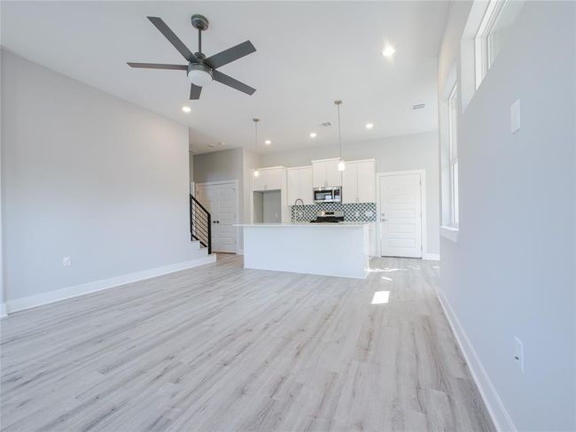 Unfurnished living room with stairway, recessed lighting, light wood finished floors, and a ceiling fan | Image 8