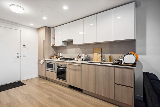 Kitchen featuring white cabinets, light wood finished floors, stainless steel appliances, and modern cabinets | Image 6