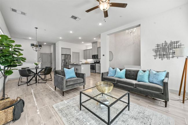 Living room featuring ceiling fan with notable chandelier and light hardwood / wood-style flooring | Image 11