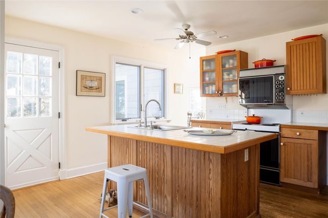 Kitchen featuring tile countertops, stove, center Island | Image 19