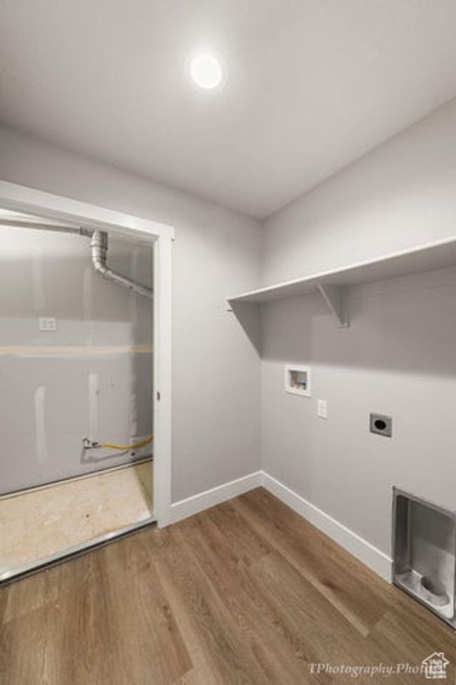 Laundry area featuring hookup for a washing machine, baseboards, wood finished floors, and electric dryer hookup | Image 13
