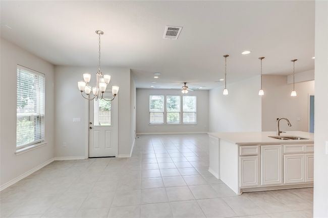 Kitchen with a sink, light countertops, recessed lighting, open floor plan, and hanging light fixtures | Image 6