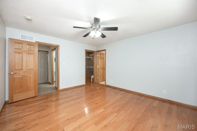 Unfurnished bedroom featuring light wood-style floors, baseboards, a closet, a spacious closet, and a ceiling fan | Image 22