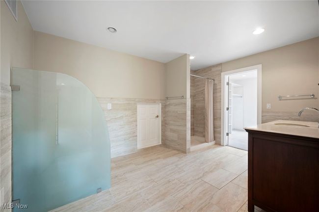 Bathroom with a stall shower, vanity, tile walls, and recessed lighting | Image 27