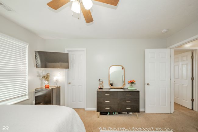 bedroom with light carpet, ceiling fan, and baseboards | Image 30