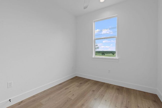 Spare room with baseboards, ceiling fan, and light wood-type flooring | Image 20