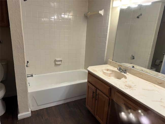 Full bath with wood finished floors, vanity, and bathing tub / shower combination | Image 16