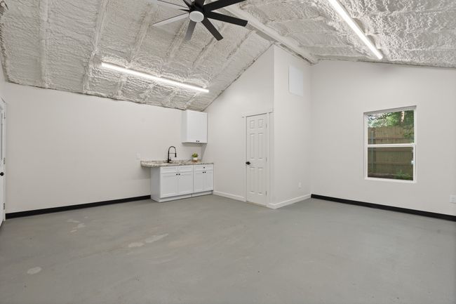 Spare room with concrete flooring, a sink, baseboards, a ceiling fan, and lofted ceiling | Image 26