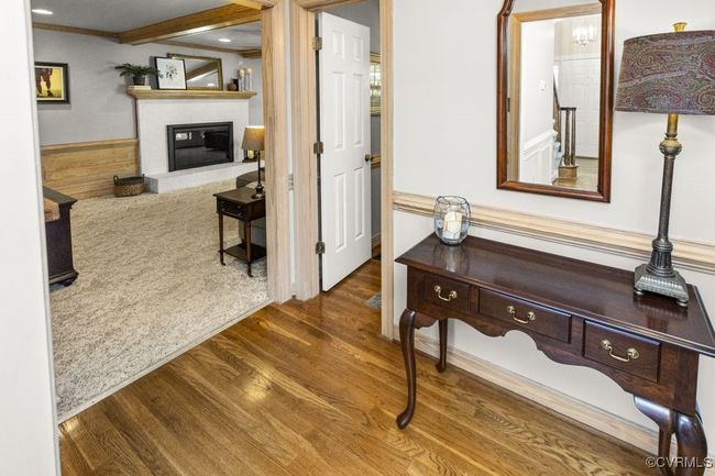 Hall featuring wood finished floors, ornamental molding, and a wainscoted wall | Image 13