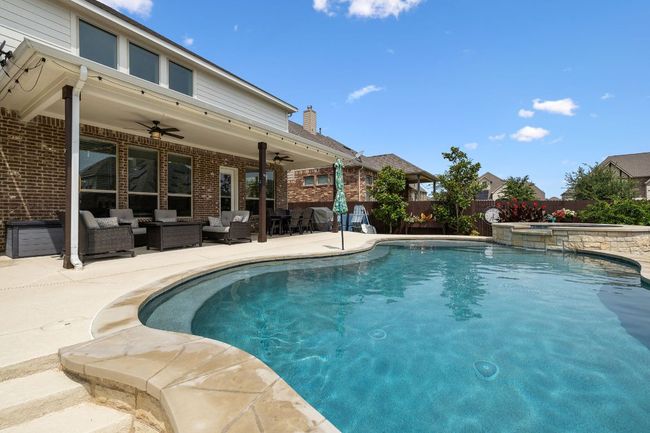 View of covered patio overlooking the pool and hot tub | Image 6