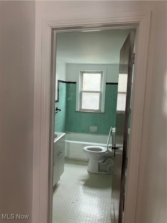 Full bath with toilet, tile patterned flooring, a tub, and vanity | Image 13