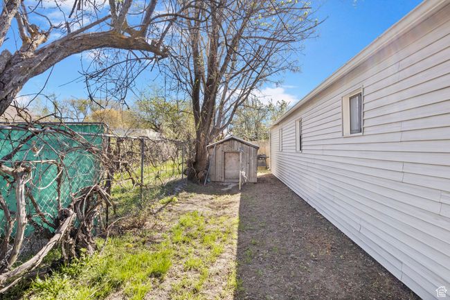 View of yard featuring a storage shed, an outdoor structure, and fence | Image 48