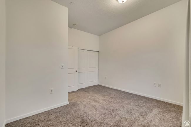 Unfurnished bedroom with baseboards, a closet, carpet floors, and a textured ceiling | Image 24