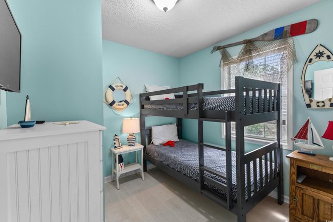 Bedroom with wood finished floors, a textured ceiling, and baseboards | Image 20