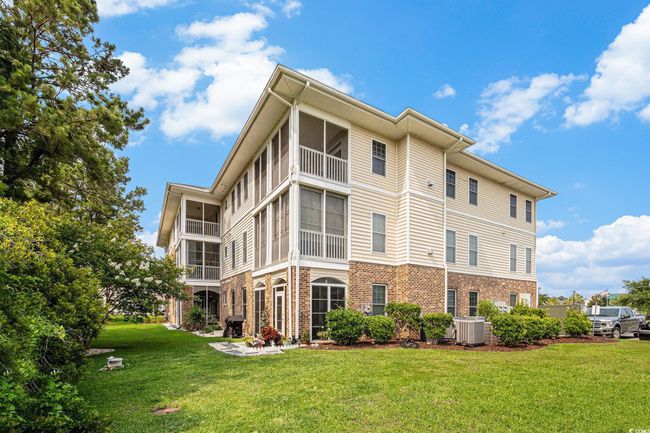 Rear view of house with brick siding, a lawn, and central AC unit | Image 30