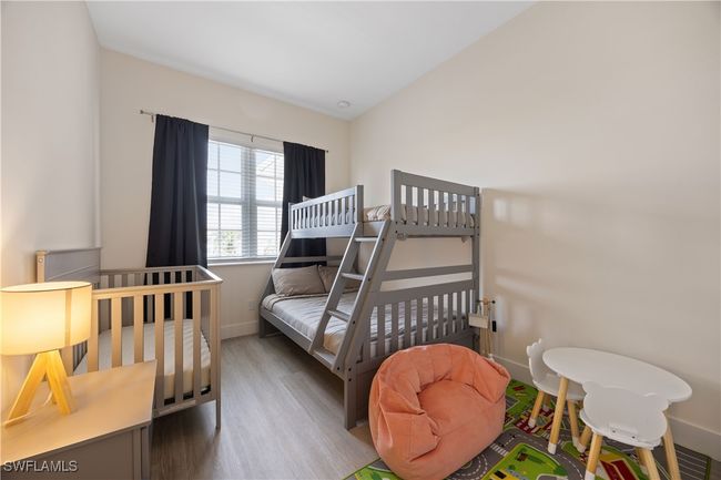 Bedroom with baseboards and wood finished floors | Image 9